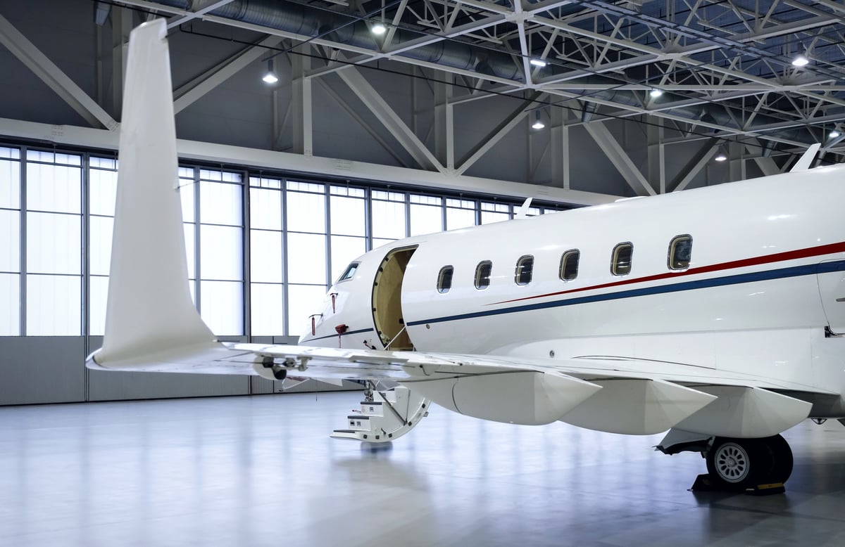 Luxury business jet airplane being stored inside an aviation hangar