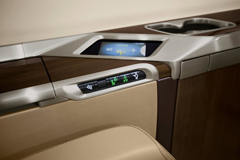 Luxury car interior showing door panel with integrated digital displays and control buttons in beige and dark wood trim