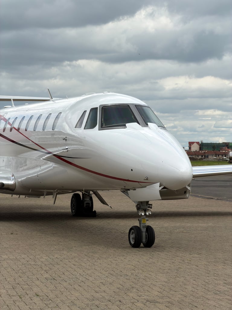 White business jet parked on tarmac with cloudy sky in background
